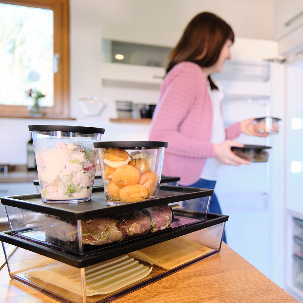 Ornamin-Blog-nachhaltig-zu-hause-plastikfrei-leben Frau stellt ORNAMIN Mehrwegschalen in den Kühlschrank