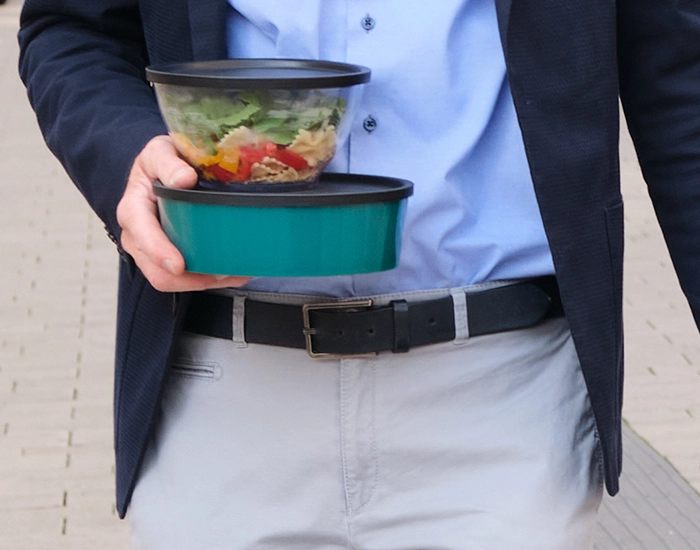 ORNAMIN-to go-Mehrwegschalen zum Mitnehmen Ein Manager hält Take-Away-Boxen in der Hand