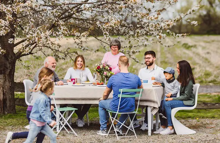 ORNAMIN-Familie sitzt draußen an einem Tisch mit Ornamin Geschirr