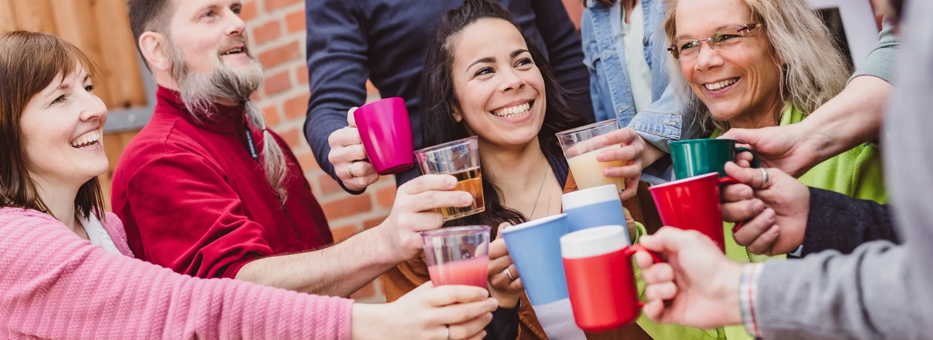 ORNAMIN-Geschirr-Becher-Header Lächelnde Menschen stoßen mit ORNAMIN Bechern an