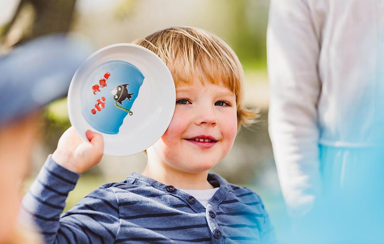 ORNAMIN-Kinder mit Kindergeschirr am Tisch