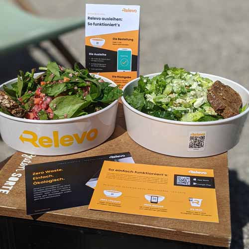 Zwei Mehrwegschalen im Relevo Mehrwegsystem sind gefüllt mit Take Away-Gerichten