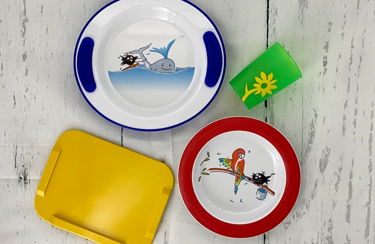 ORNAMIN-Kindgerechtes Pflegegeschirr Auf dem Tisch stehen vier Produkte aus der Kinder-Pflegeserie. our products from the children's care range on the table.
