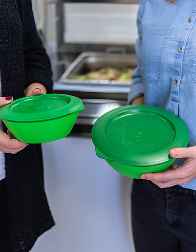 Zwei Personen halten grüne Eco to go Boxen in den Händen