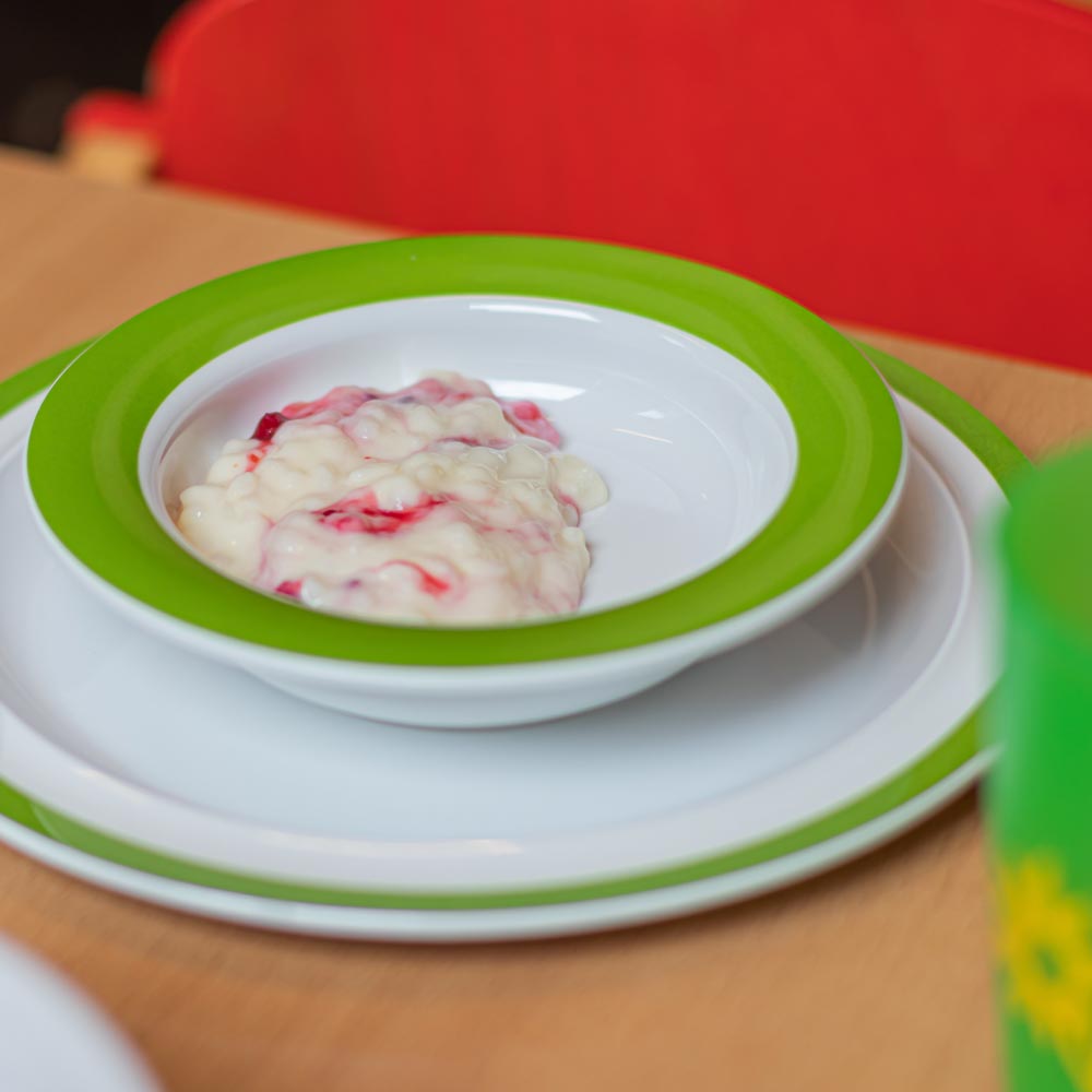 ORNAMIN-Mehrweg-Kinderteller-mit-Essen-auf-einem-Esstisch-in-der-Kita