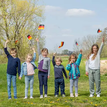Kinder auf einer Wiese mit Deutschlandflaggen