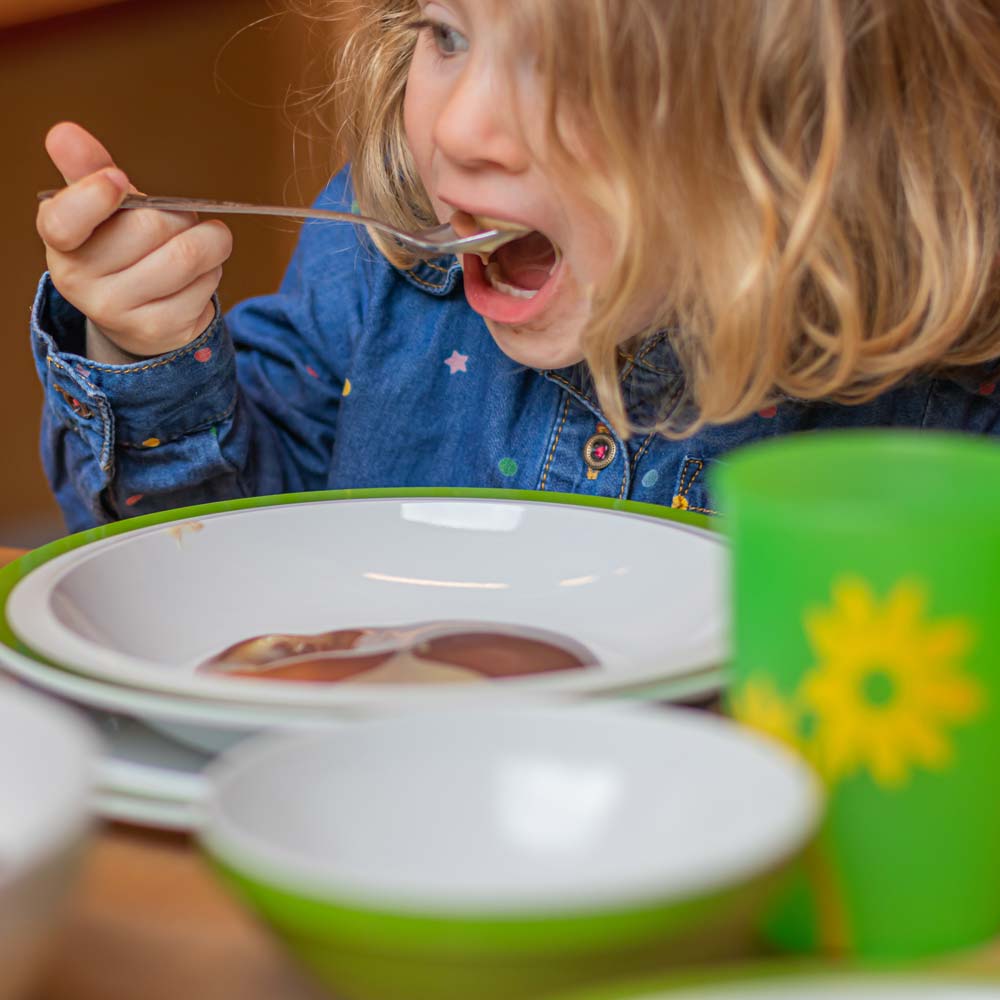 A child in the kindergarten eats from ORNAMIN reusable children's tableware