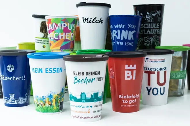 ORNAMIN-Mehrwegsystem-Referenzprojekte der Coffee to go-Becher Anordnung vieler to go-Becher in den individuellen Designs der verschiedenen Partner und Projekte von ORNAMIN