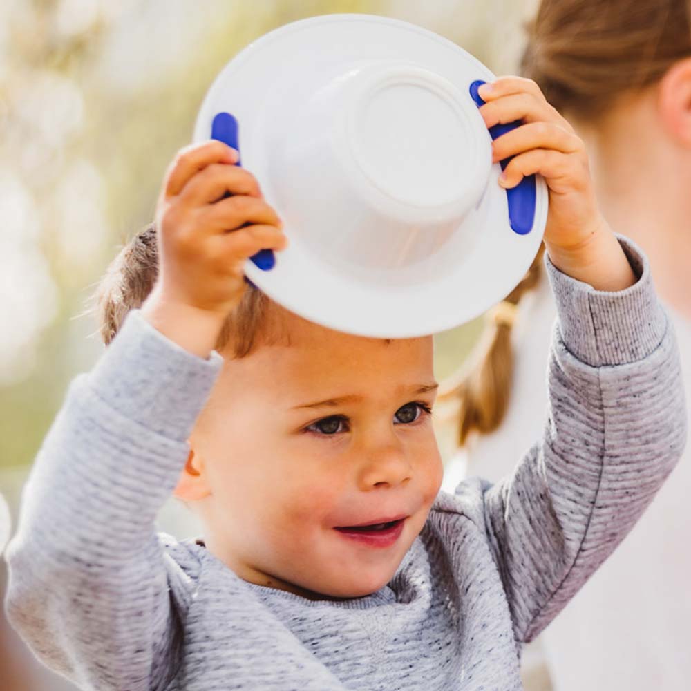 ORNAMIN Kinderteller Kind hält ORNAMIN Kinderschale über den Kopf