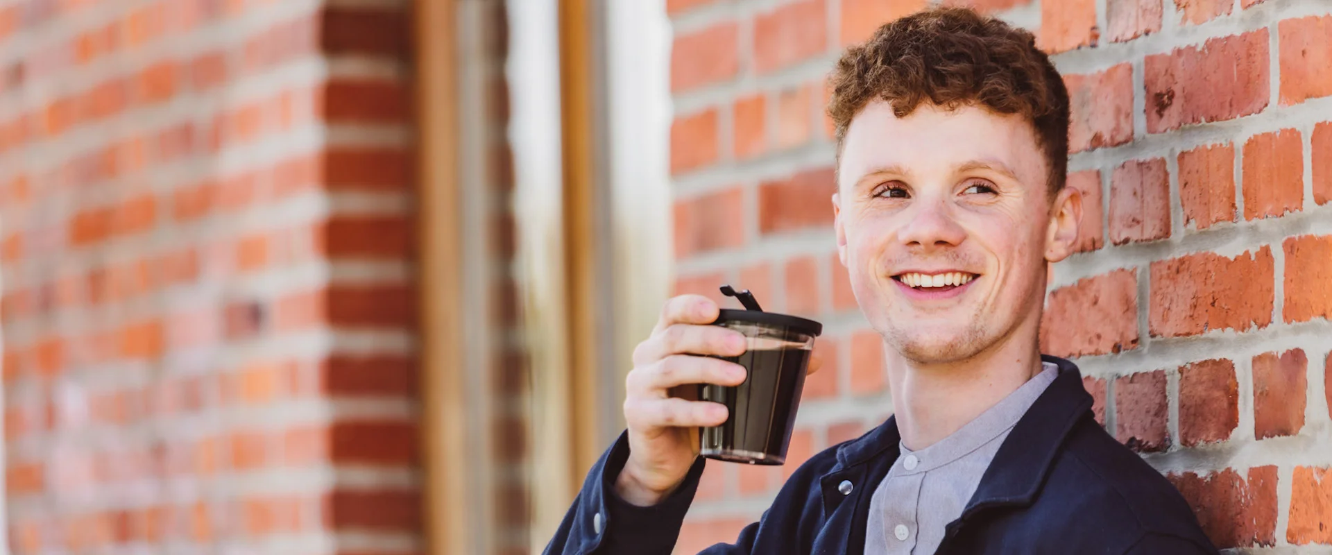 ORNAMIN-Coffee-to-go Ein junger Mann mit Mehrweg-Kaffeebecher