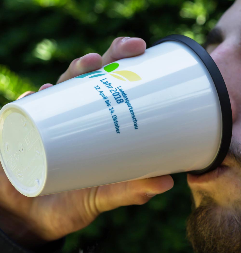 Person trinkt aus einem ORNAMIN Coffee to-go Mehrwegbecher